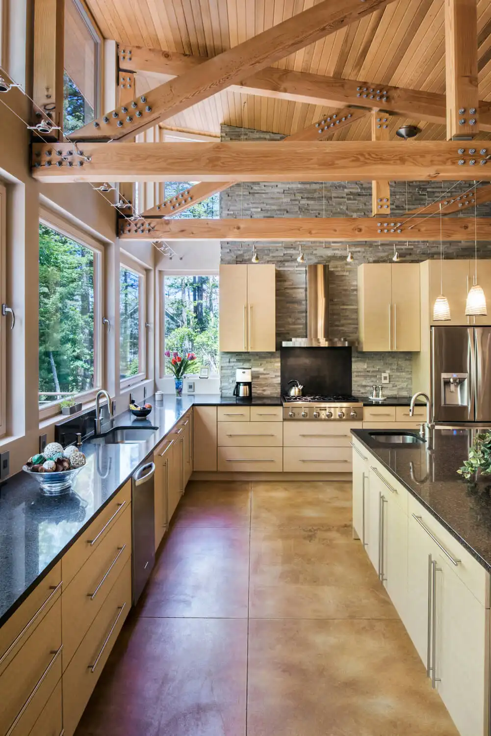 Kitchen with timber frame ceiling, European tilt-turn windows overlooking forest, open plan living
